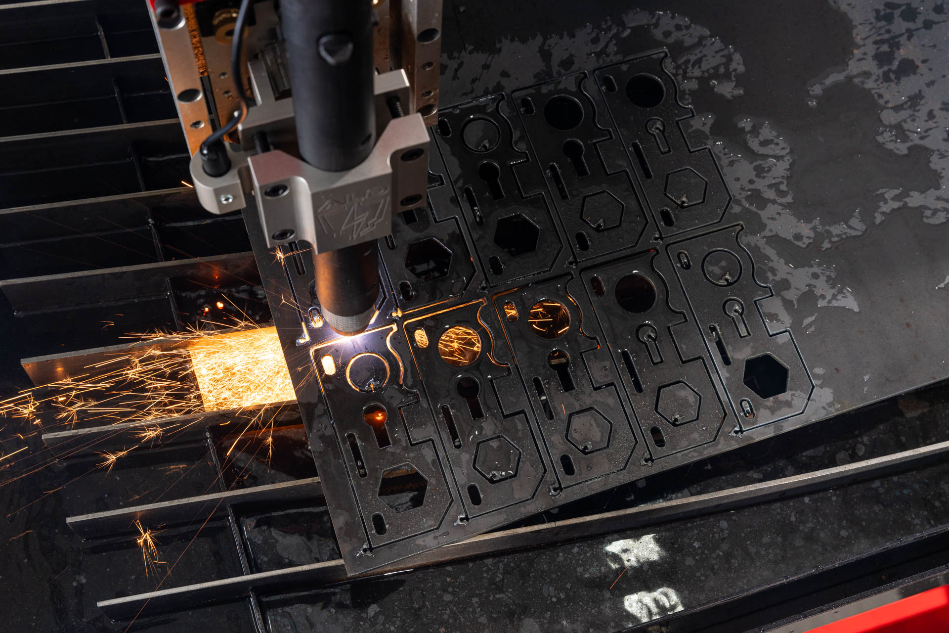 Arc Pro Ultra V3 cutting head close-up — plasma flame mid-cut on metal plate.